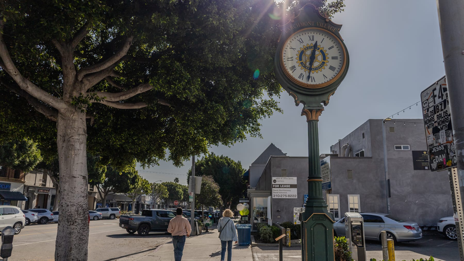 Green street clock on Larchmont Boulevard with shoppers walking past